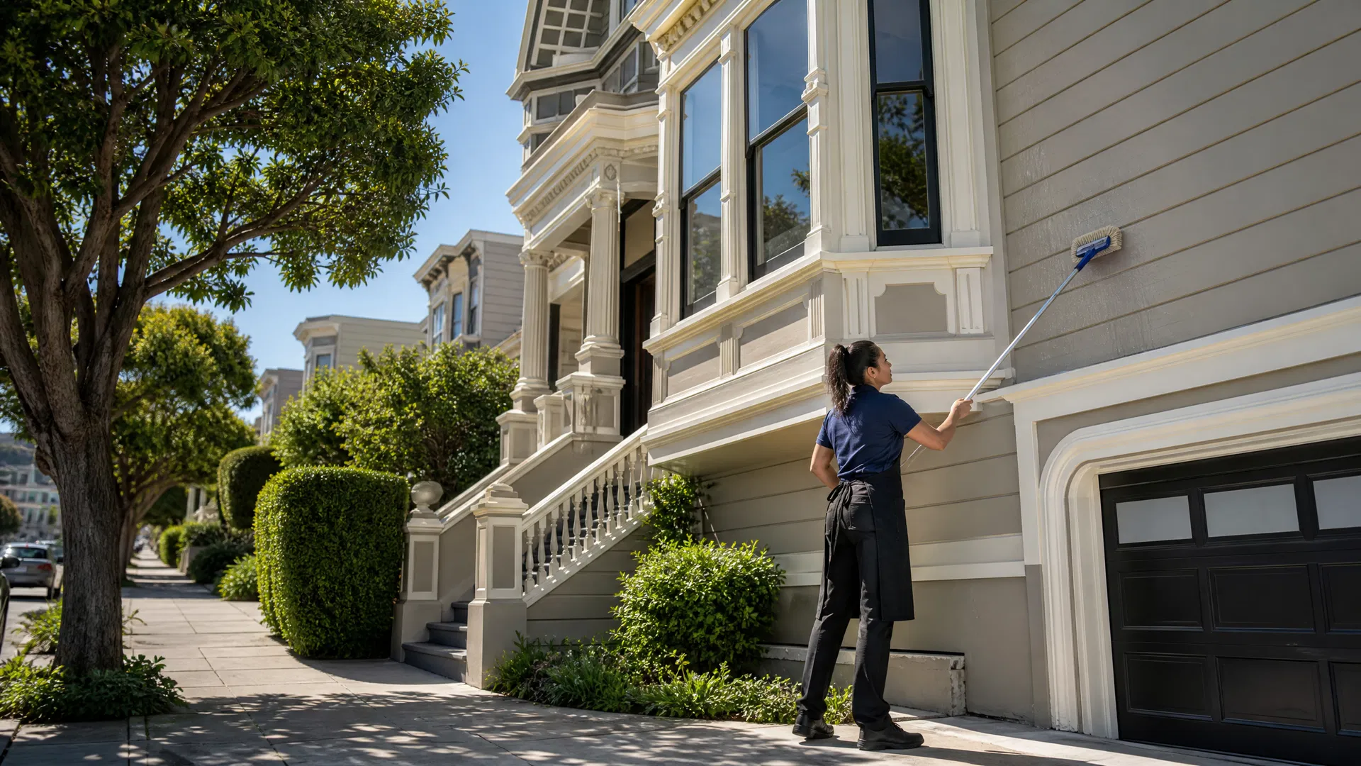 Professional cleaner washing Victorian home exterior in San Francisco